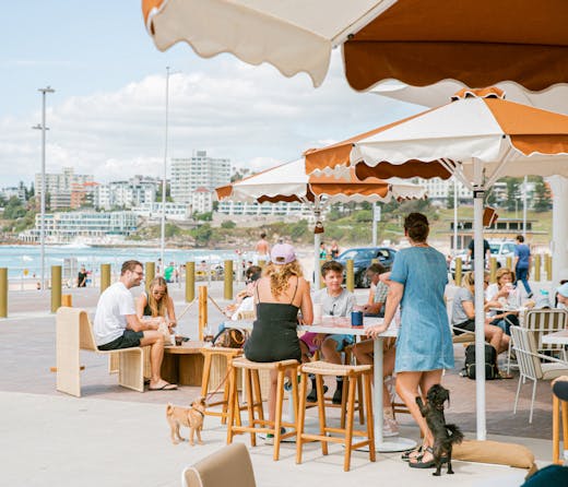 People sit under umbrellas at Glory Days cafe on Bondi Beach