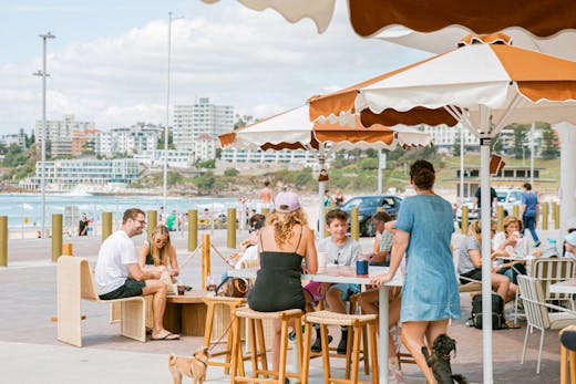 People sit under umbrellas at Glory Days cafe on Bondi Beach