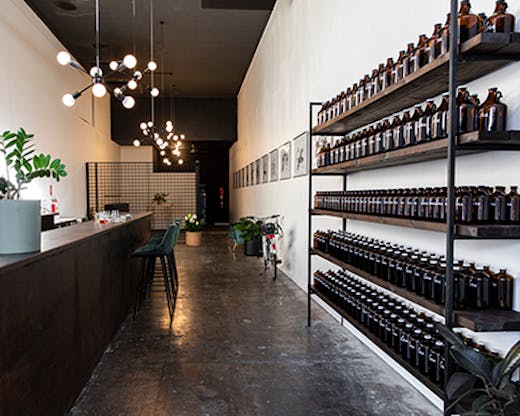 A long, minimally-designed wine bar with bottles on the right hand wall.