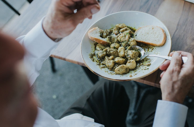 A bowl of gnocchi with bread 