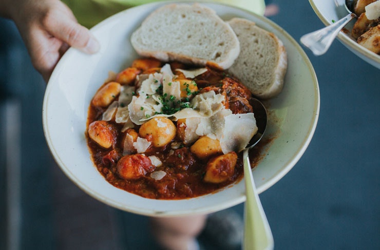 A bowl of gnocchi with bread 