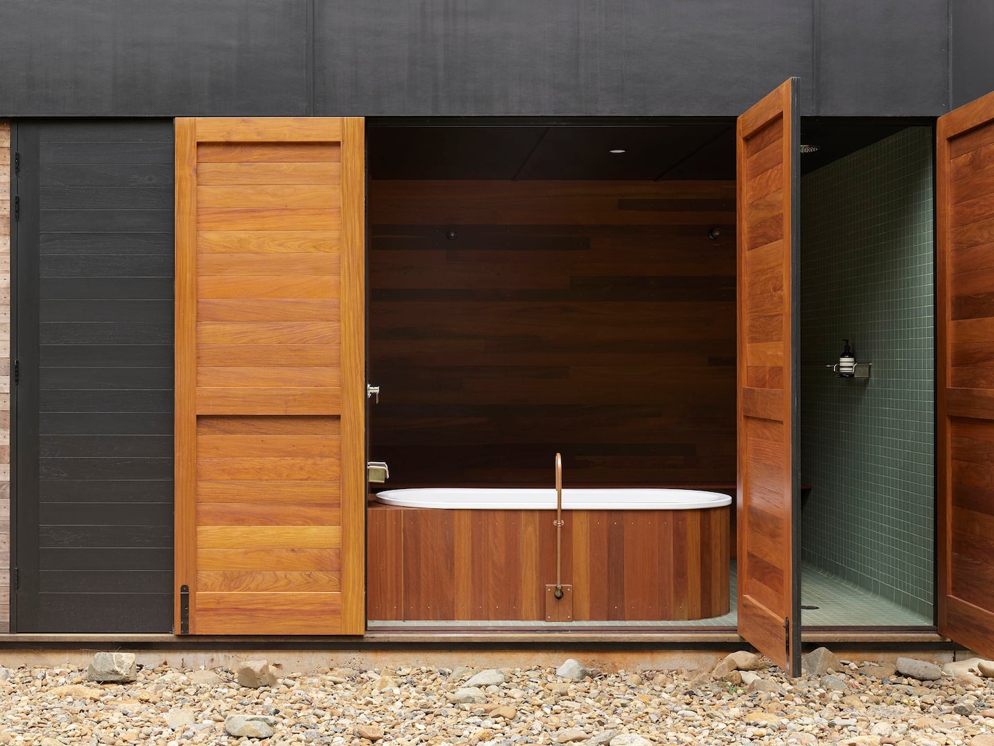 a bath in a bathroom with walls that open to the outside