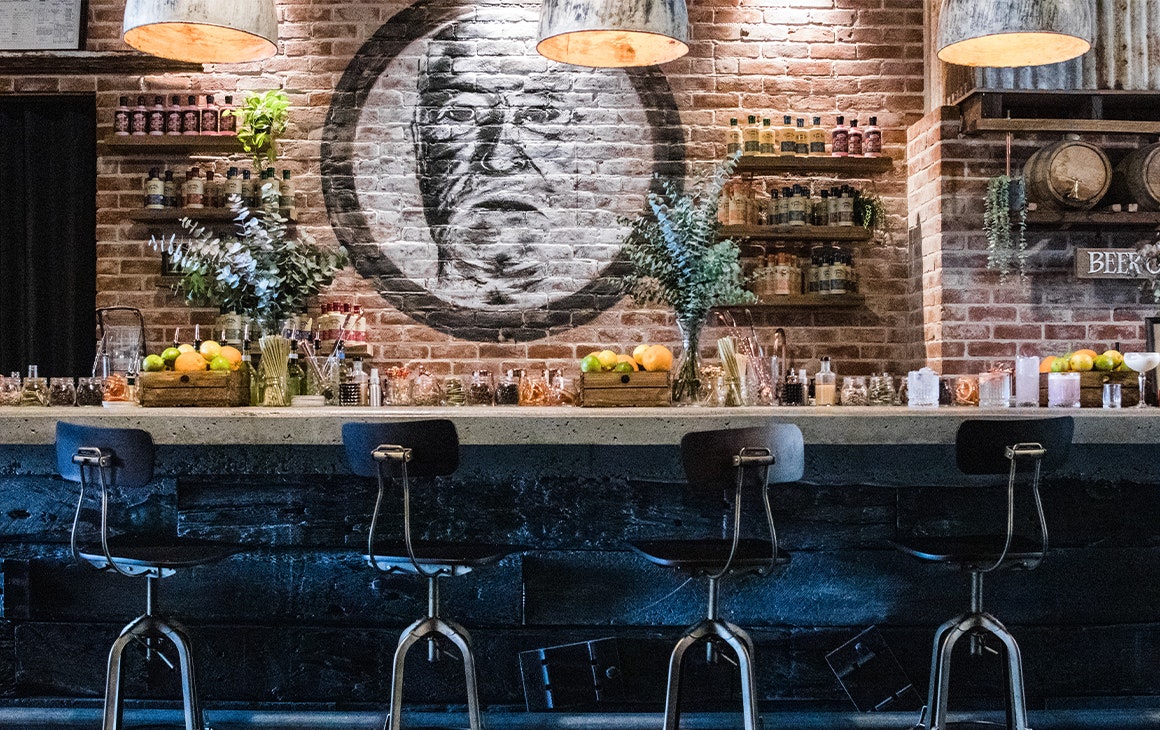 bar inside granddad jacks, with stools and a brick wall behind