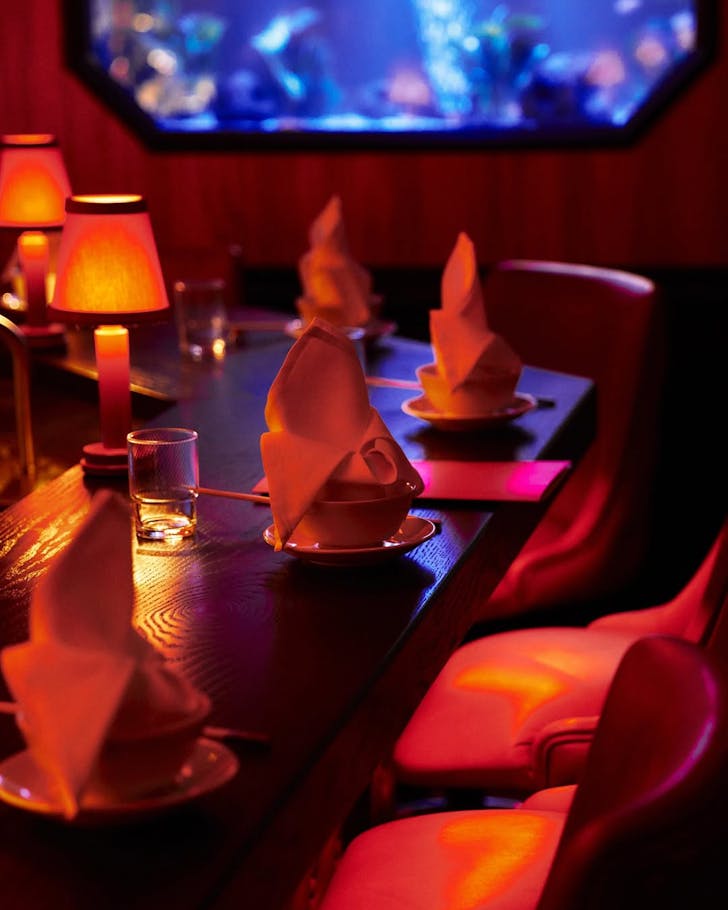 A red lit table with a fish tank in the background