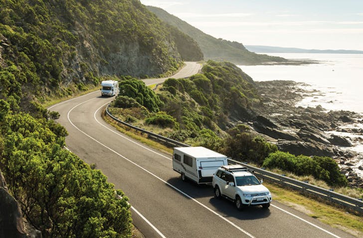 A car with a caravan on the great ocean road, a best scenic drive victoria