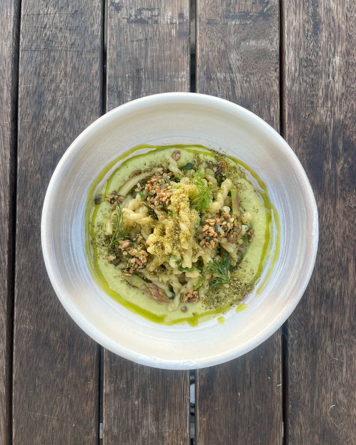 A bird's eye view of a bowl of pasta with green sauce