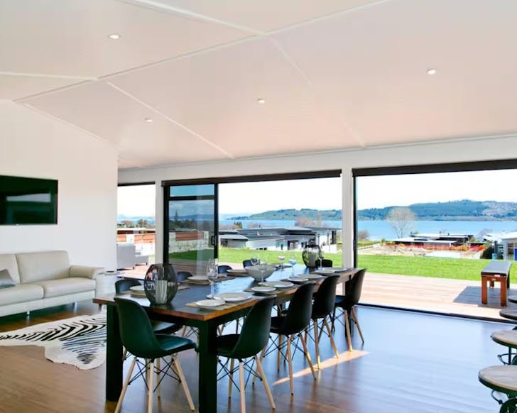 A modern dining room looking out toward a lake.
