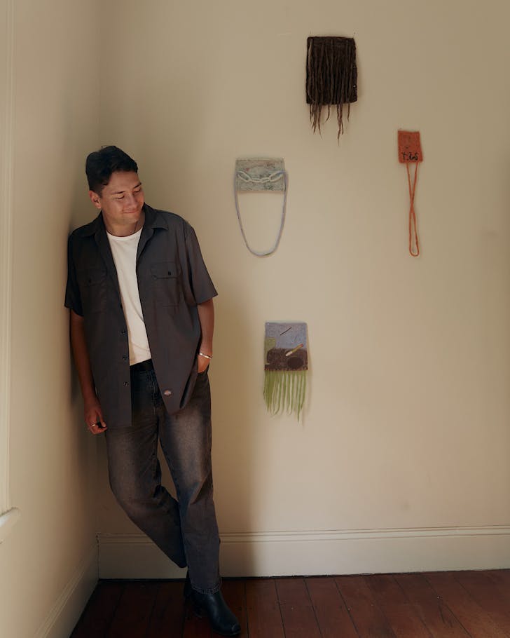 HÄmiora Bailey stands in the corner of a room, contentedly beside some minimalist yet striking wall art. 