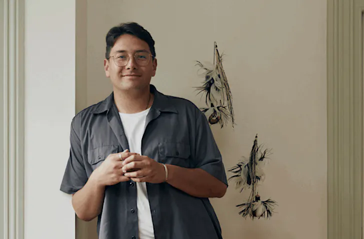 Hāmiora Bailey leans against a wall with a content expression. 