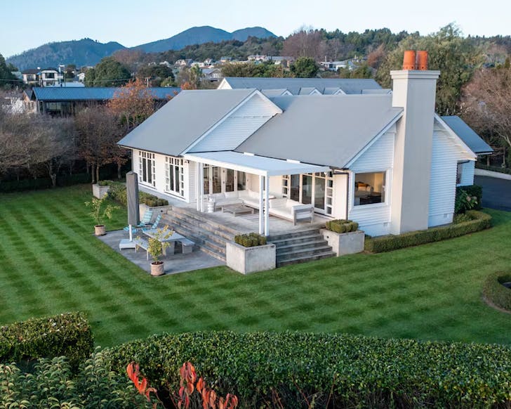 A large white Hamptons-style house on exquisitely manucured grounds.