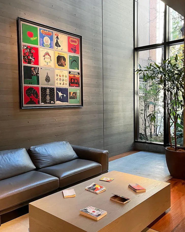 The lobby of a hotel with colourful art on the walls and a leather lounge