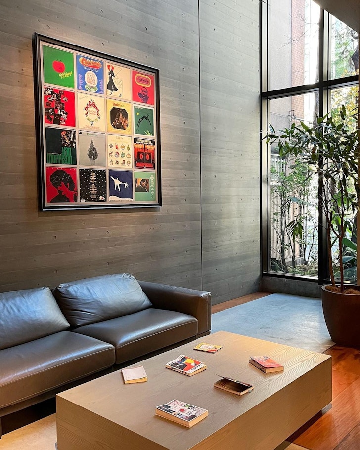 The lobby of a hotel with colourful art on the walls and a leather lounge