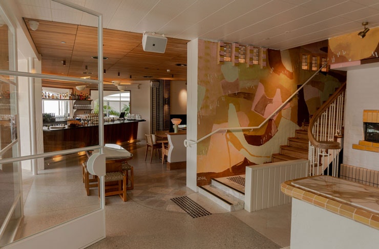 The entrance and a mural by the stairs at the new Harbord Hotel. 