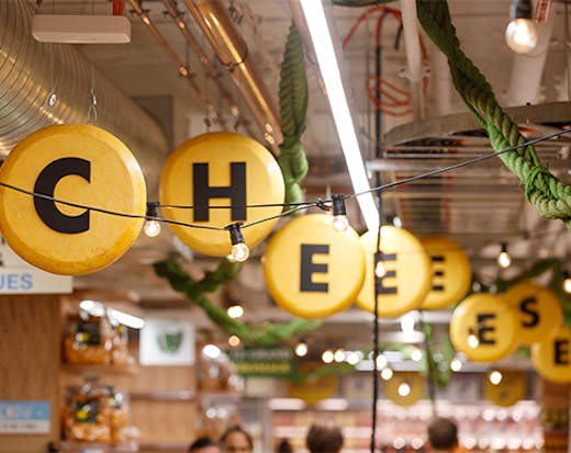  sign hanging from a ceiling saying 'cheese'