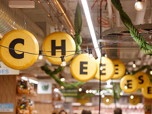 sign hanging from a ceiling saying 'cheese'