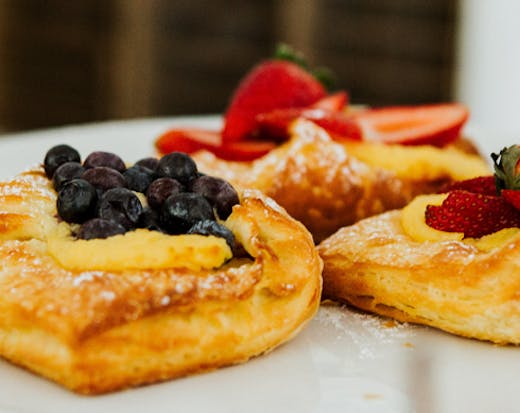 three pastries sit on a white tray.