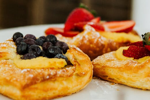 three pastries sit on a white tray.