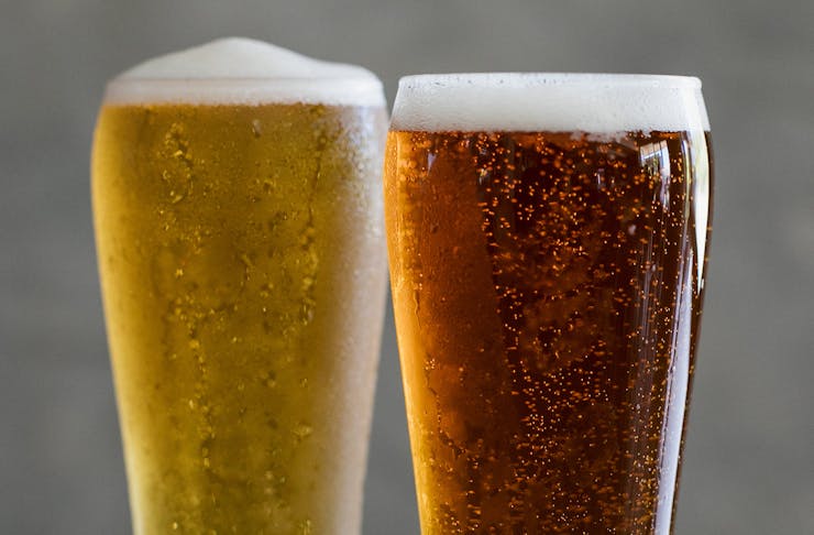 A close up shot of two glasses of freshly-poured beer. 