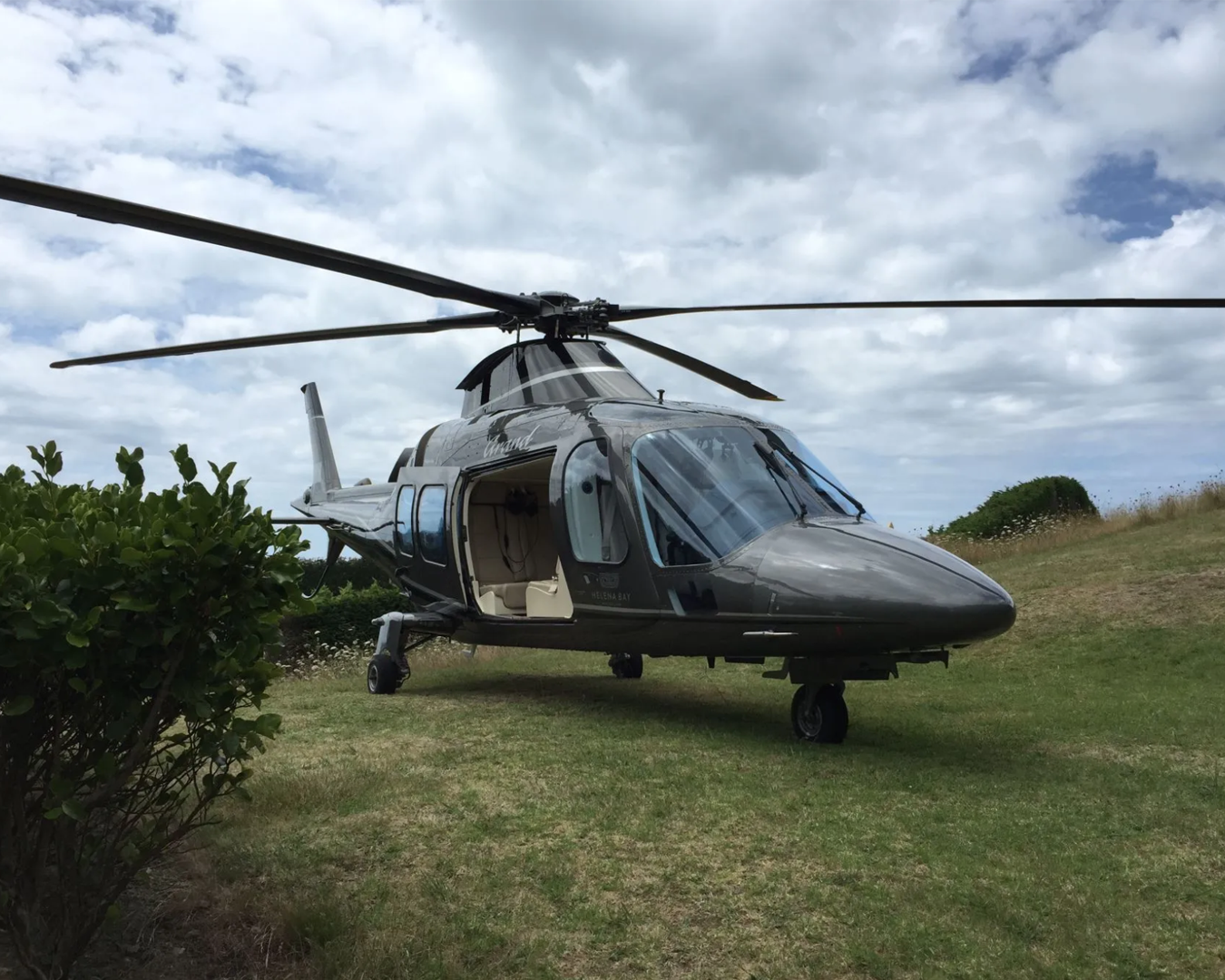 A helicopter parked on grass outside Mudbrick Winery