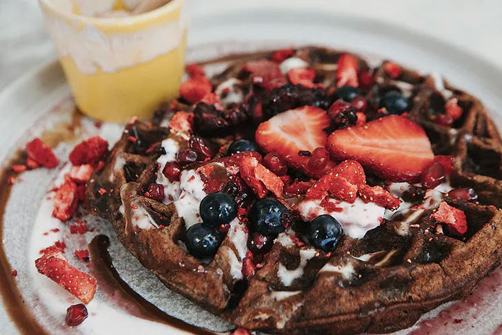 The berry and banana waffle at Hemi sits on a plate looking beautiful.
