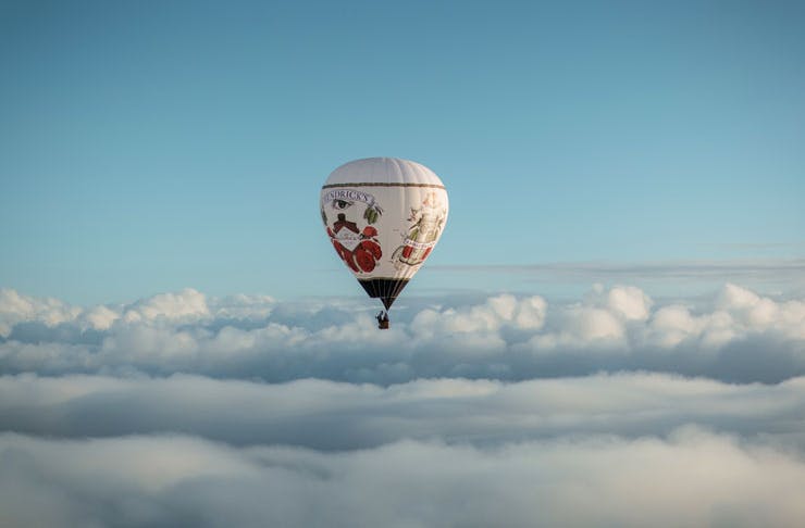 The Hendricks Hot Air Balloon Bar in flight over some clouds. 