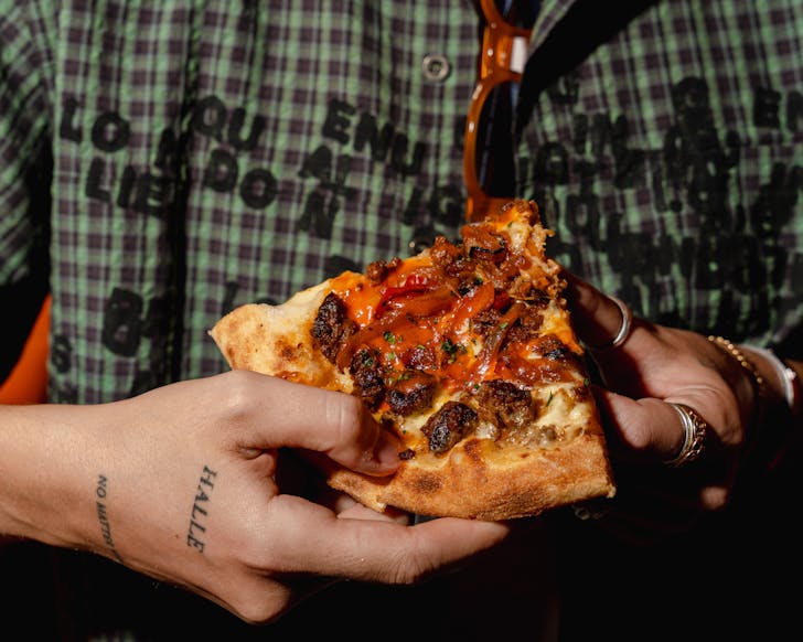 Man holding a slice of pizza
