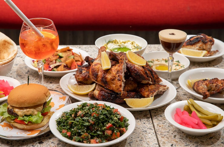 A table set with various dishes from Henrietta and cocktails. 