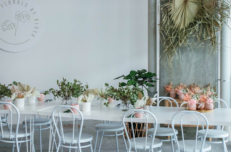 Long White table decorated with pink and white pot plants at Florals By Blush