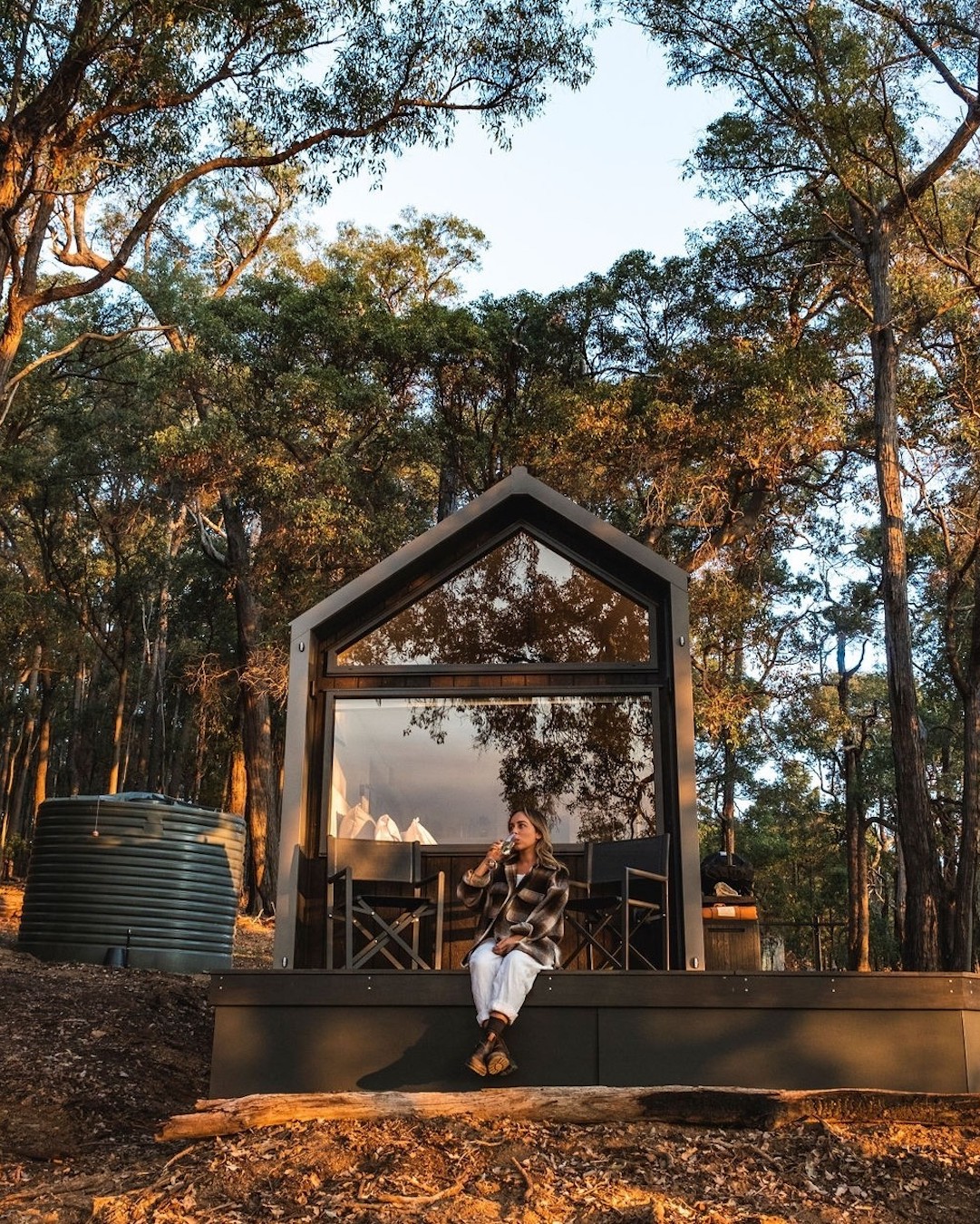 Someone sitting on the deck of a Hidden Cabin tiny home