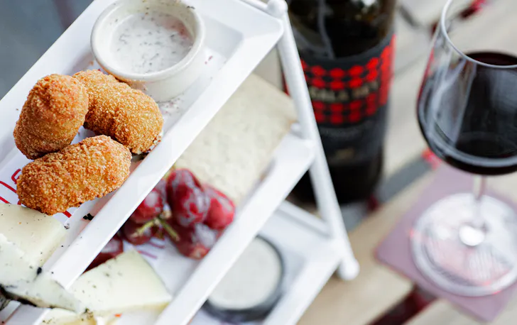 a tower of cheesy snacks and a glass of wine