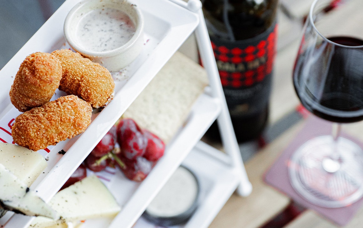 a tower of cheesy snacks and a glass of wine