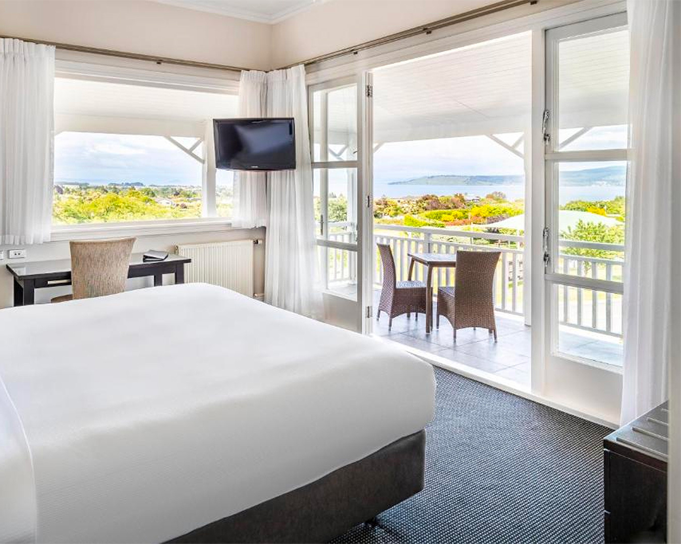 A sumptuous room with a balcony and views at the Hilton Lake Taupo, one of the best hotels in Lake Taupo.