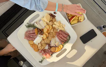 Hand grabbing over a cheeseboard