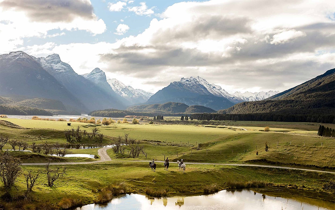 Three people sit on horseback in  stunning Glenorchy