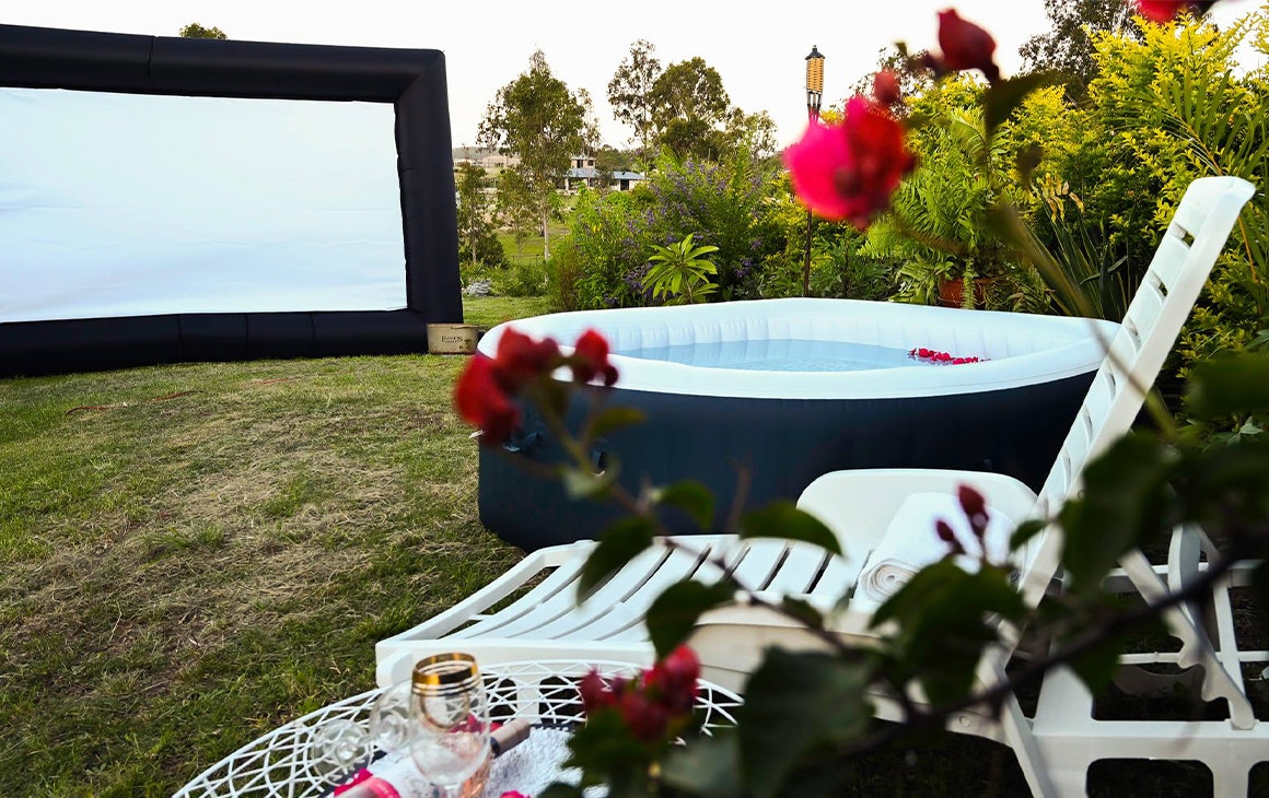 an inflatable. hot tub and movie screen in the backayrd