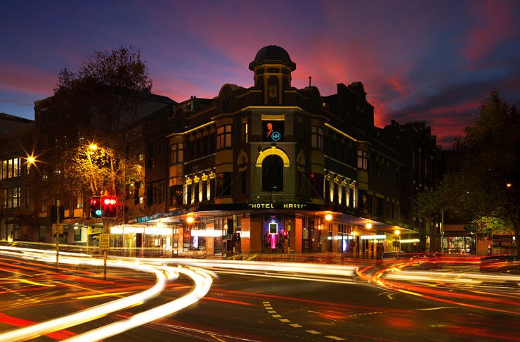 The front of Hotel Harry in Surry Hills, Sydney, at night with traffic going past. 