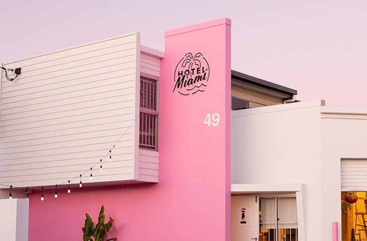 A shot of the bright pink and white timber exterior of Hotel Miami.