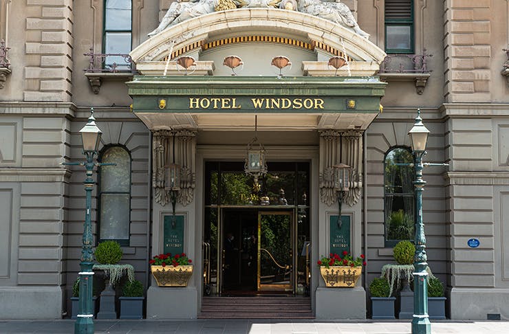 Concrete pillar entry of Hotel Windsor with light beaming across the facade 