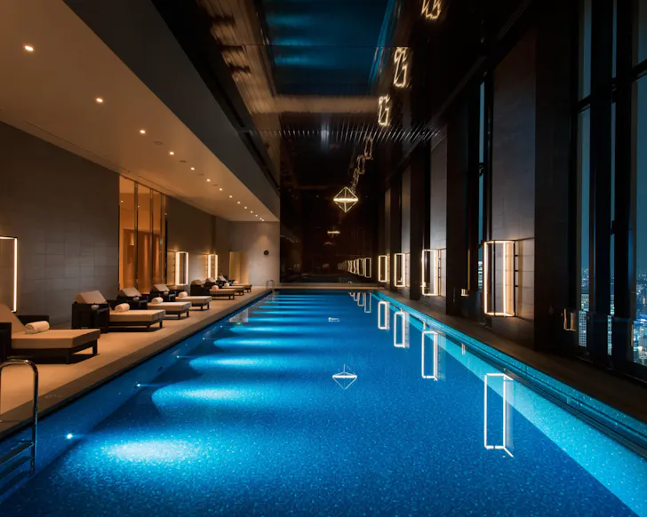 The luxurious, lit-up indoor pool with city views at Conrad Osaka. 