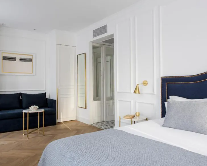 A clean, light-filled suite with parquet flooring at Hotel Midmost Barcelona.