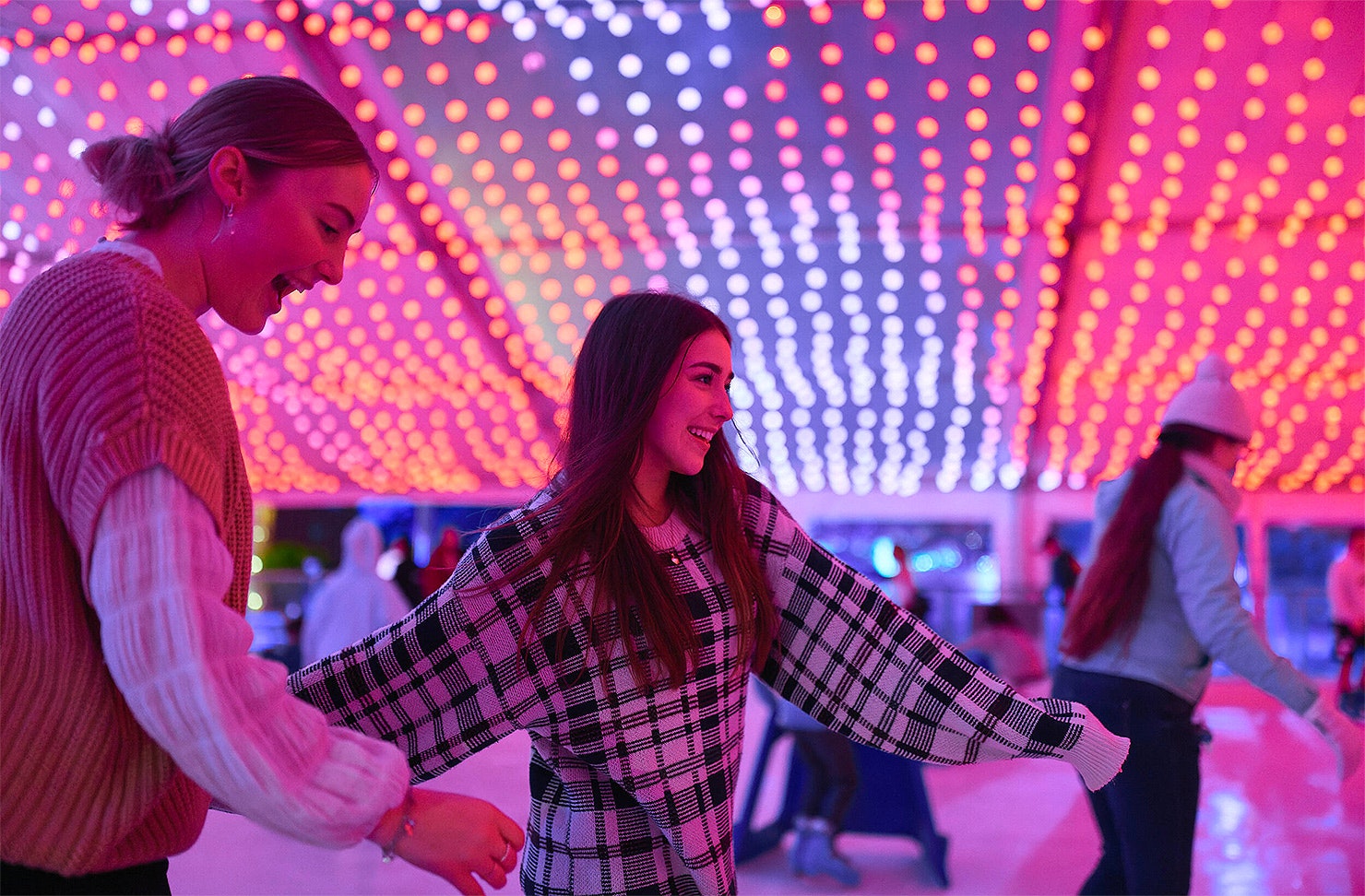 Two people enjoy the ice rink at Aotea Ice Rink.