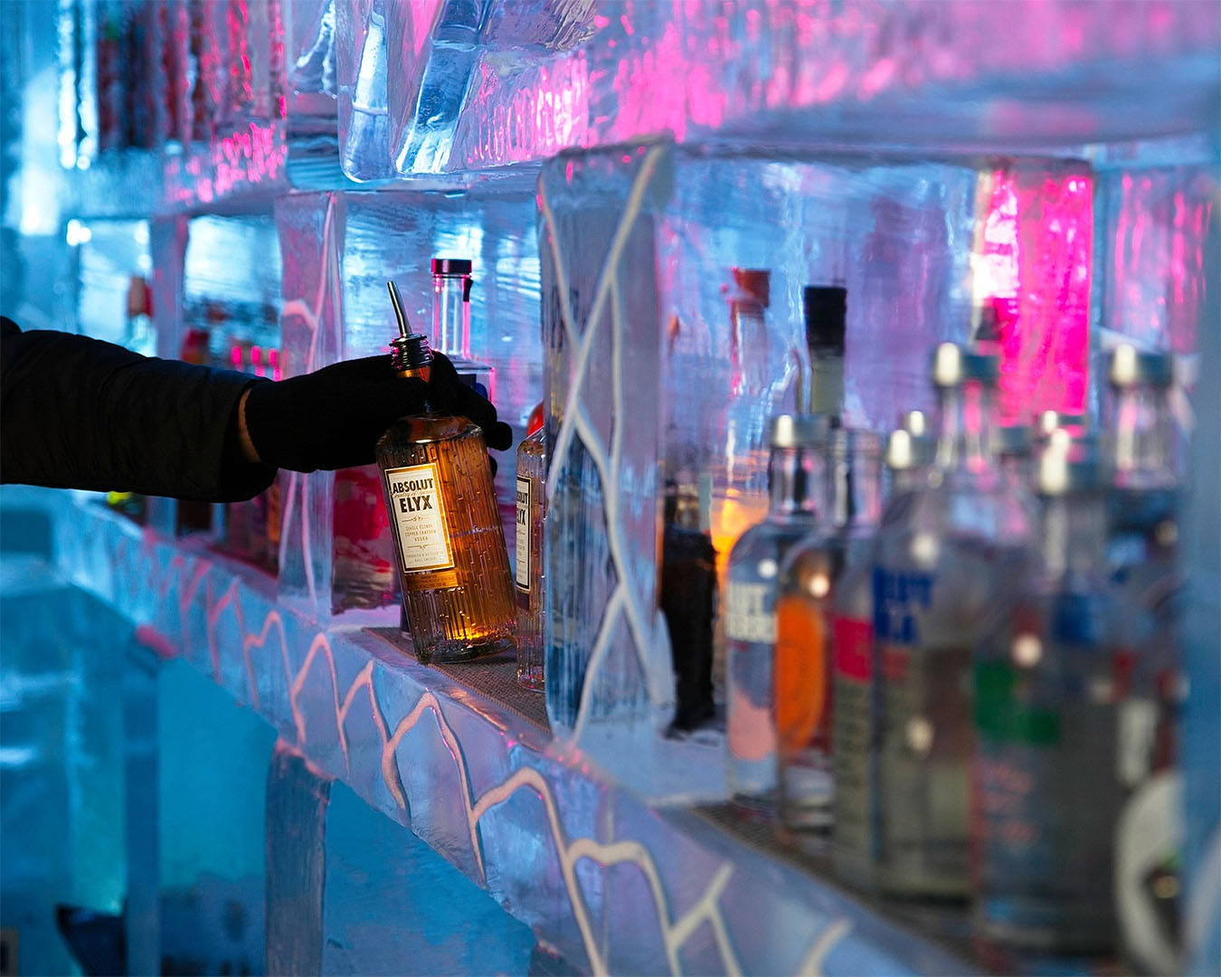 Someone takes a bottle from the ice wall at Queenstown Ice Bar, one of the best bars in Queenstown.