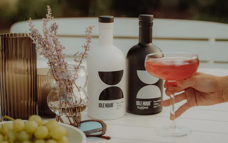 two bottles of vodka on a table with a cocktail