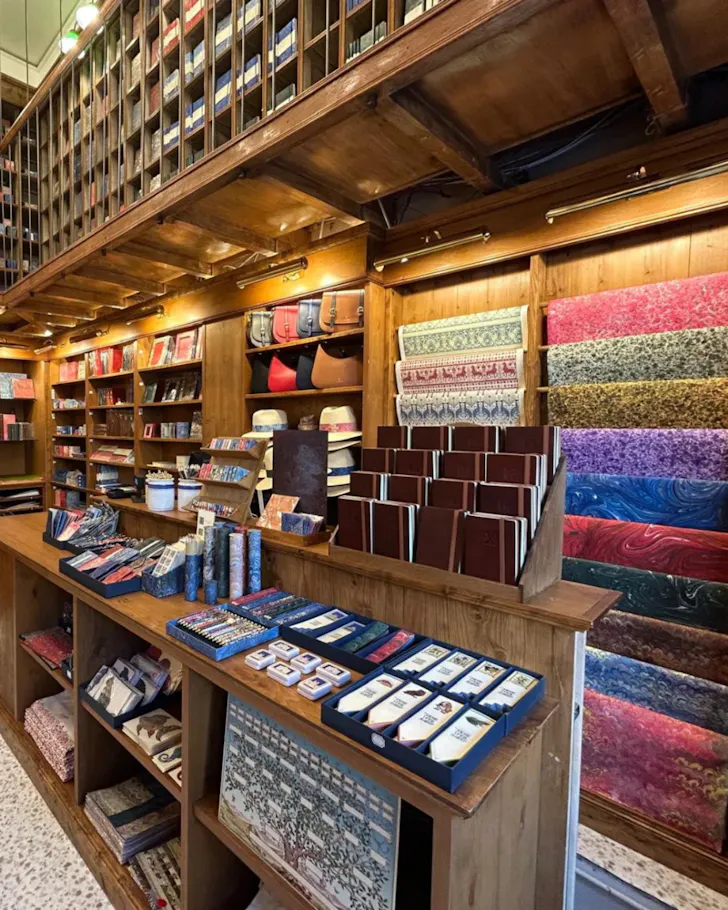 Inside an Il Papiro store lined with packed bookshelves.