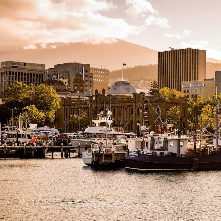 A boat sits in the harbour framed by buildings