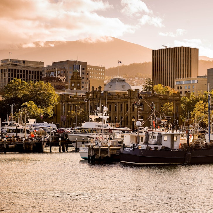 A boat sits in the harbour framed by buildings