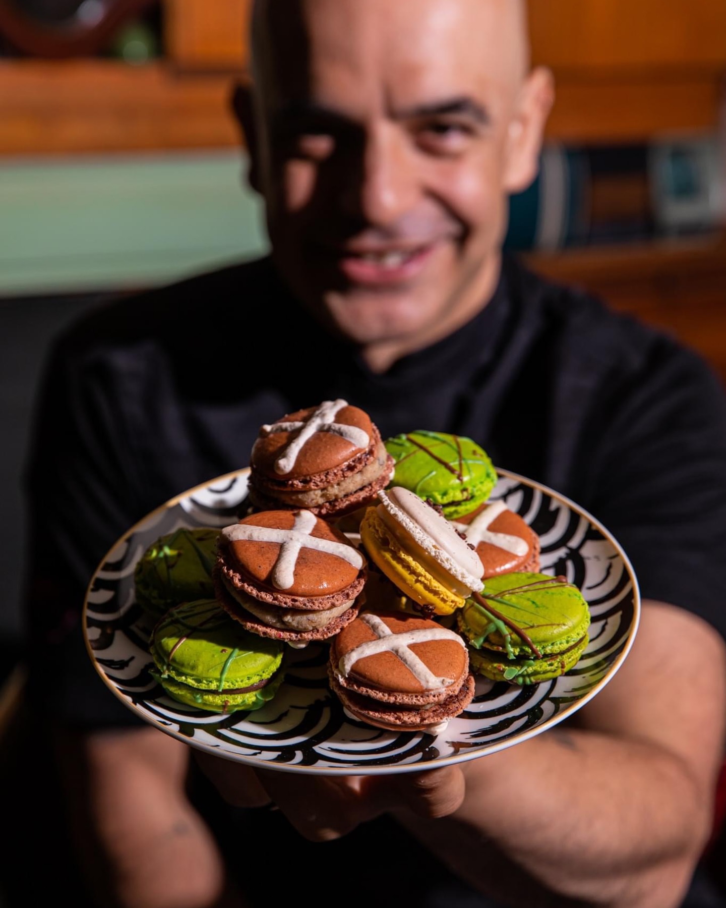 adriano zumbo holding a plate of easter themed macaroons