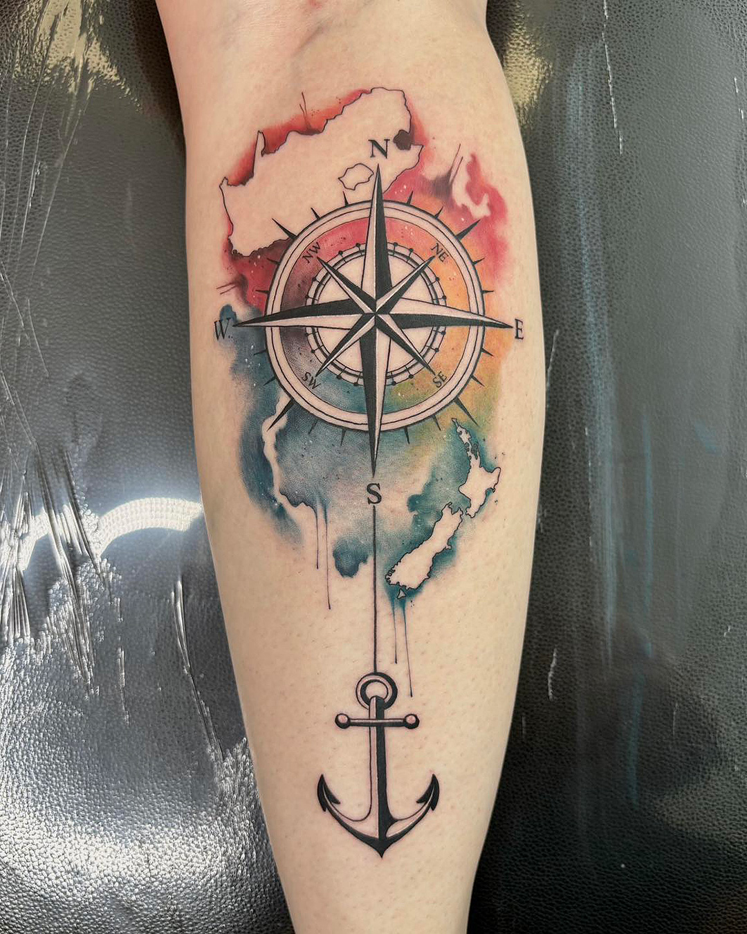 Someone with a colourful compass point on their arm.