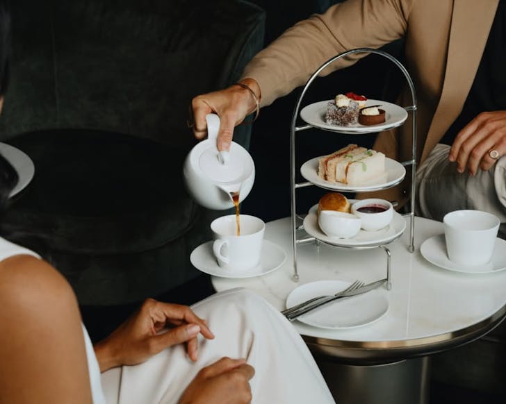 A man pours tea from a pot for a table at the Intercontinental Sydney's high tea