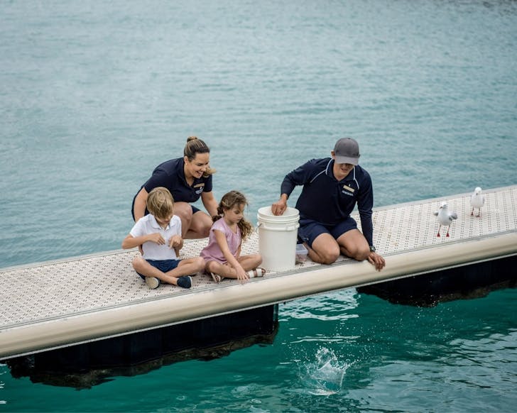 kids and staff feeding fish at the marina at intercontinental hayman great barrier reef